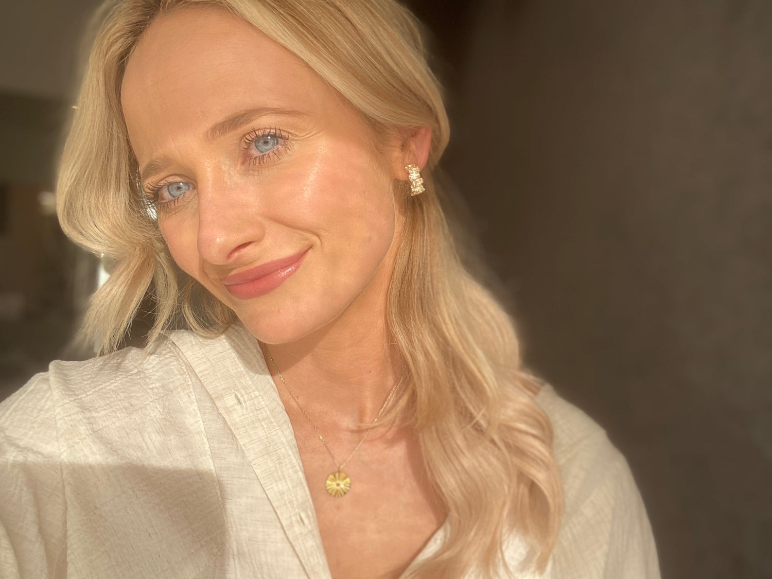 Havia model wearing gold fanned disc necklace and diamond hoops.